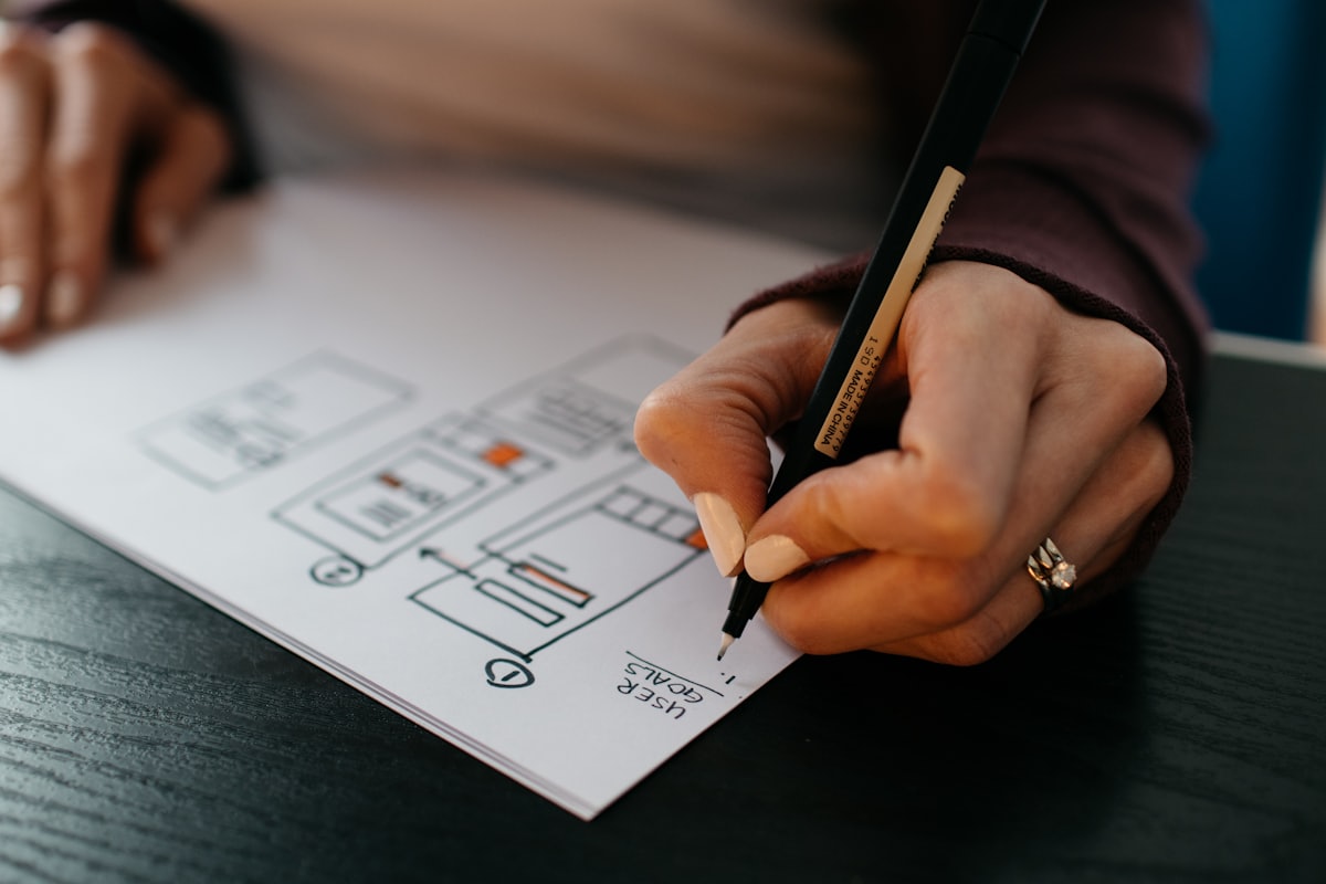 Hand sketching a system wireframe on paper