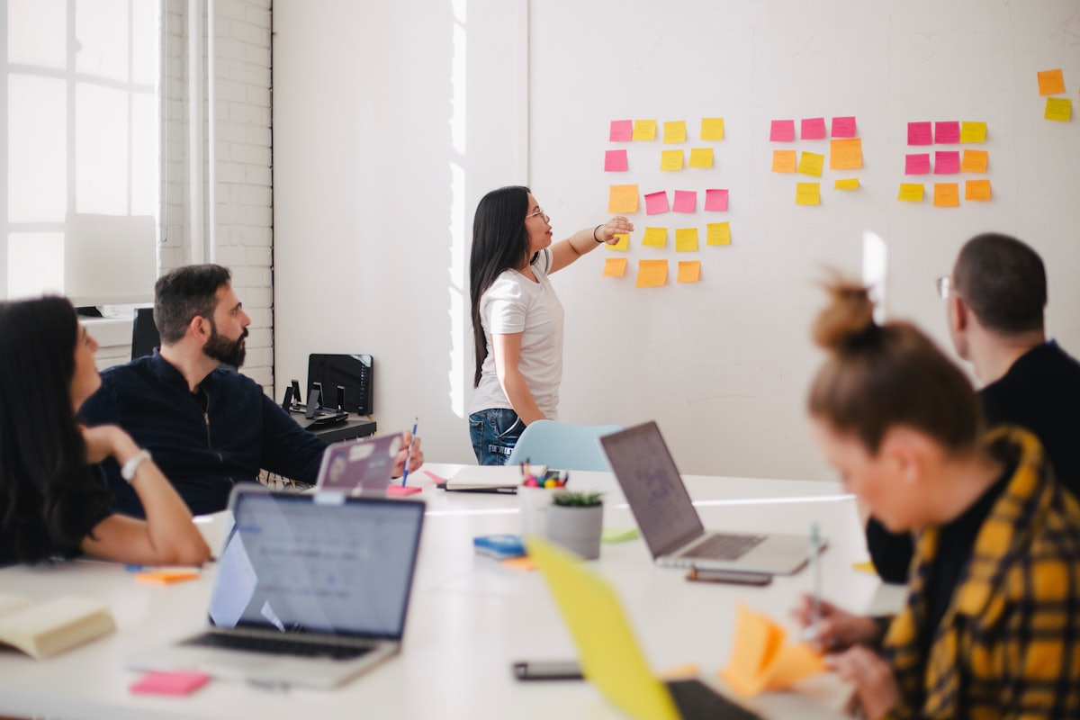 Team mapping workflows on a wall of sticky notes
